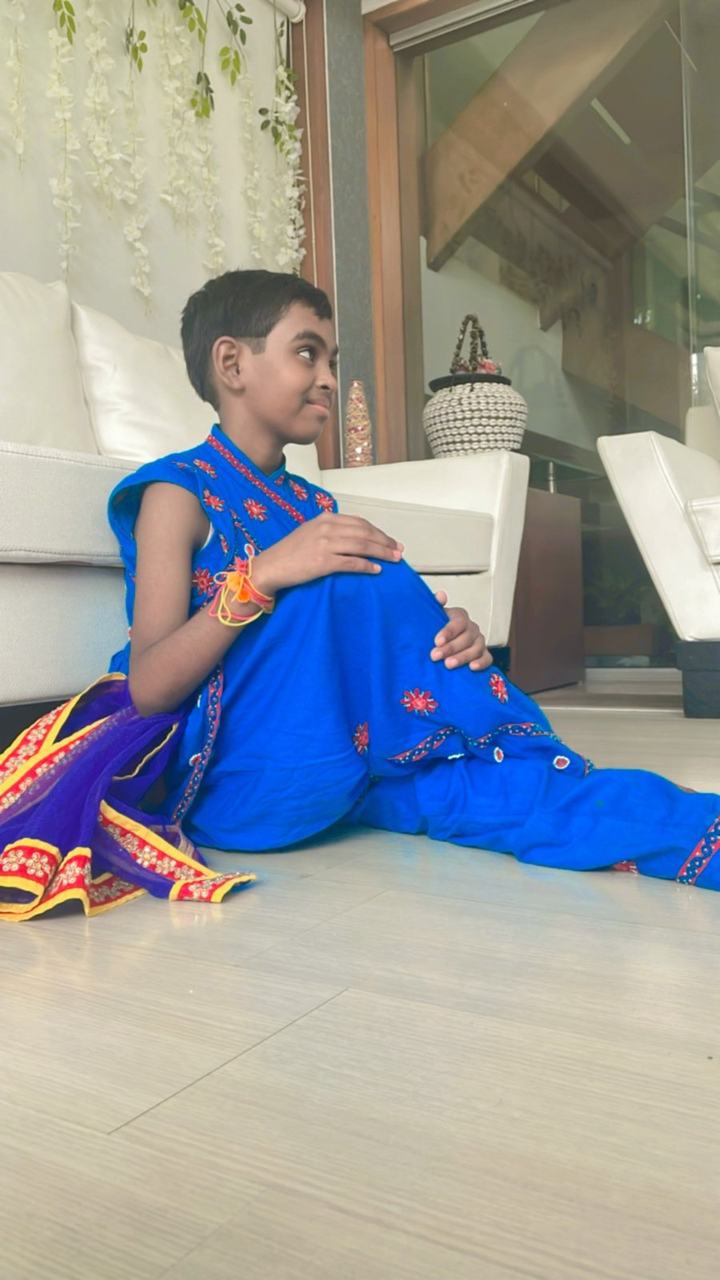 Child posing in a blue festival costume