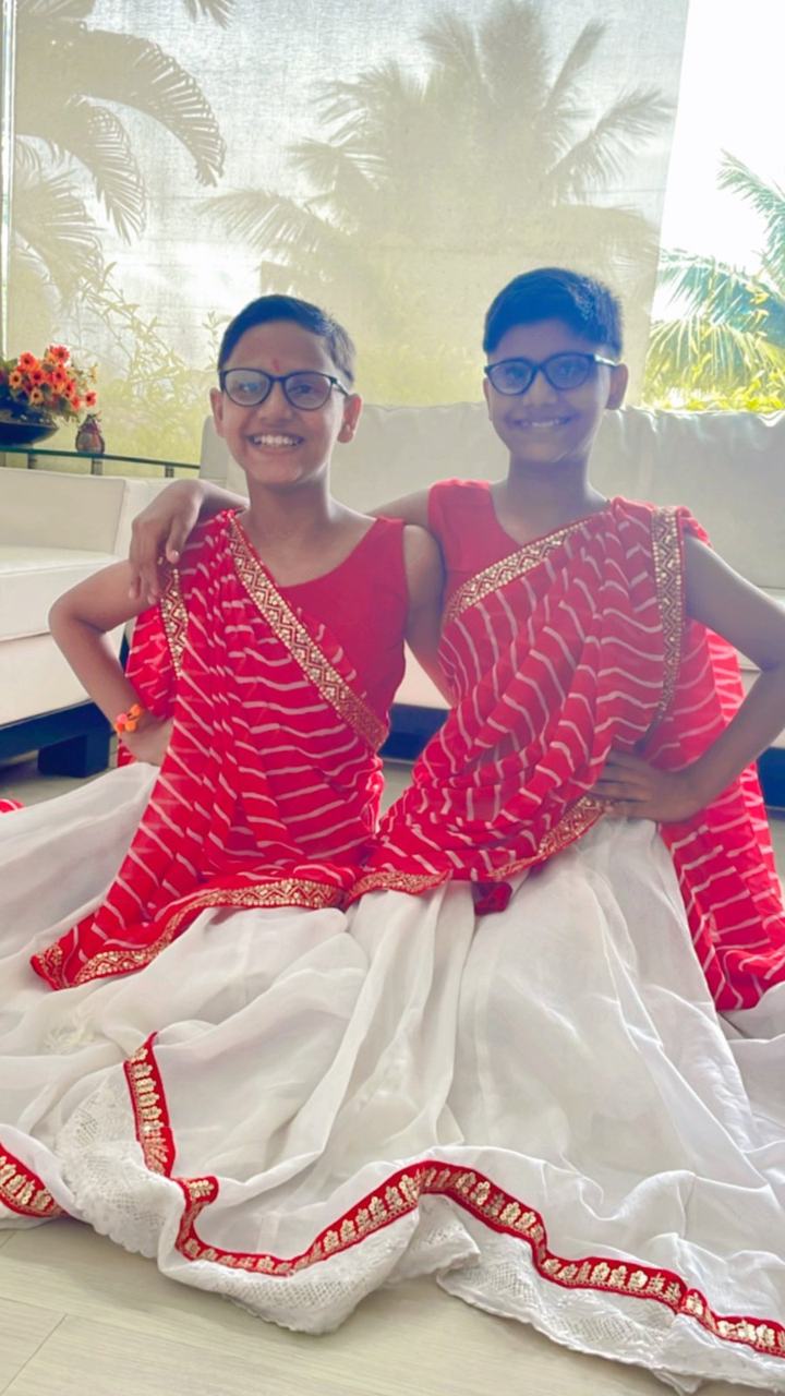 Two girls posing in red and white sarees